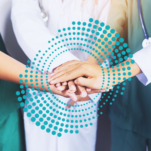 nurses hands stacked in the middle of a huddle