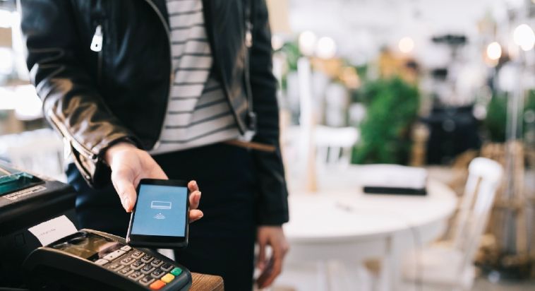 man paying by phone in store