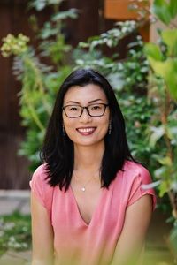 Author Kelly Yang in pink top and glasses