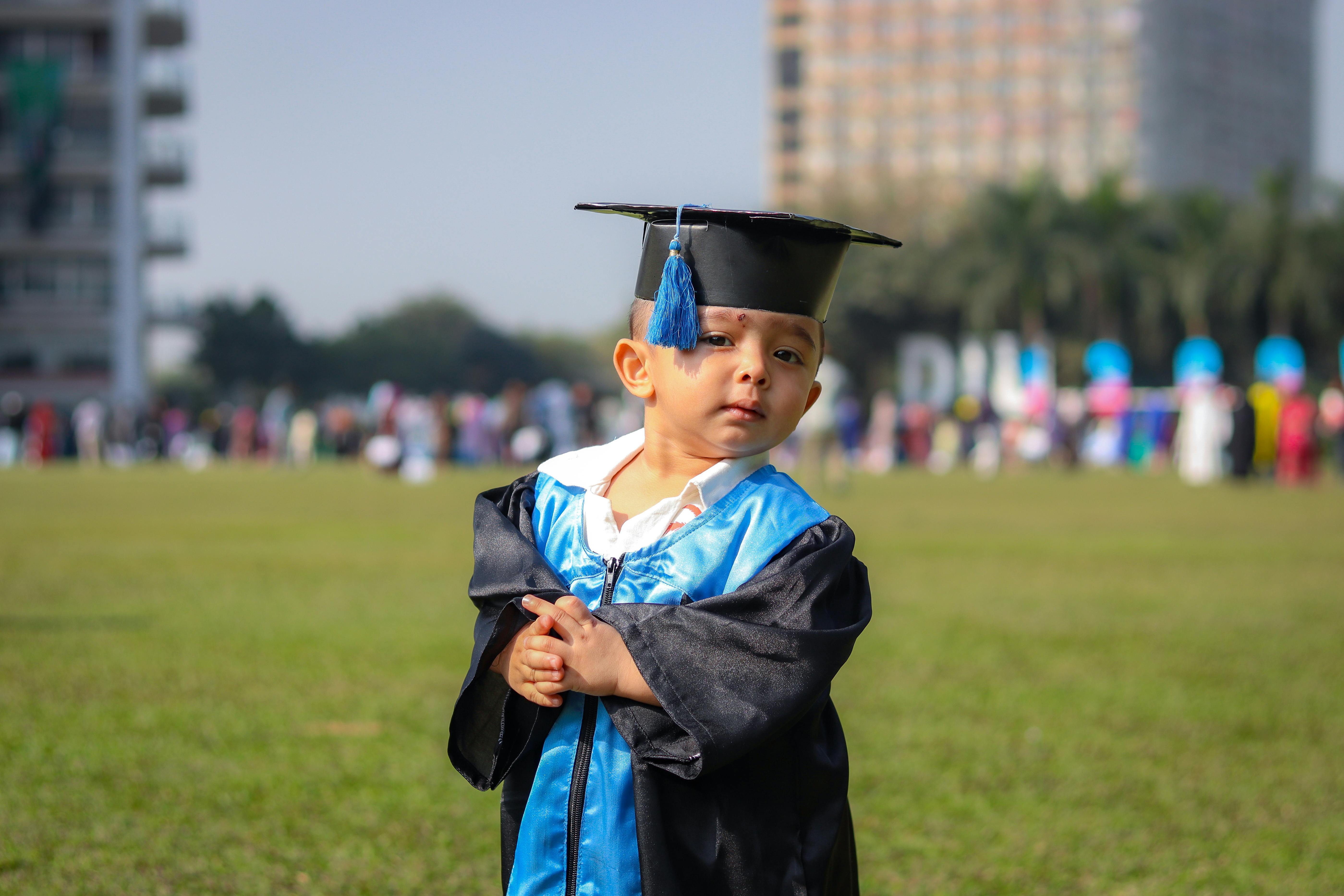 a young child in a graduation cap and gown