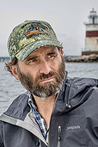 photo of author Jack Carr with hat in front of lighthouse