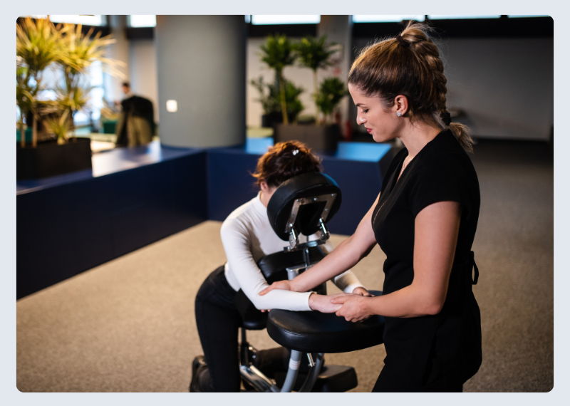 woman giving hand and arm massage to client in massage chair