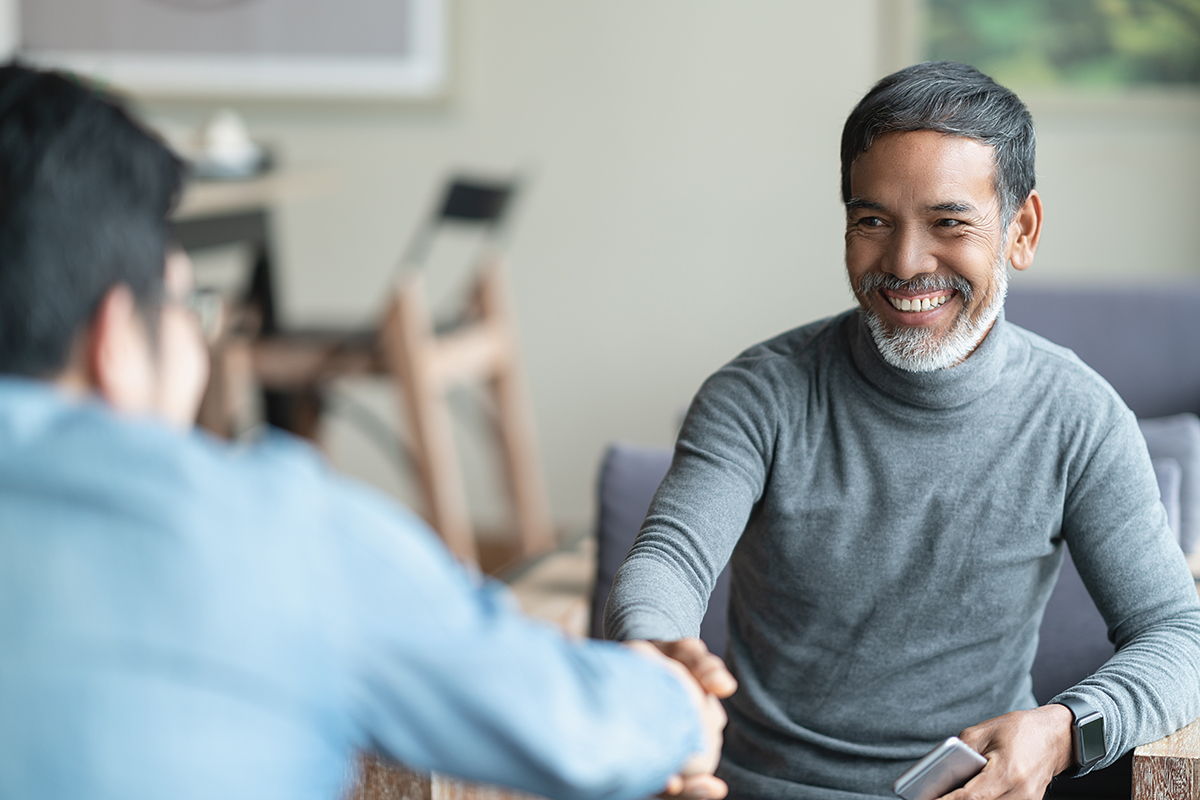 older hispanic man shaking hands