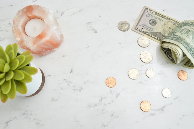 Courtesy of katie-harp from unsplash Marble table top with money, a succulent and a salt candle holder