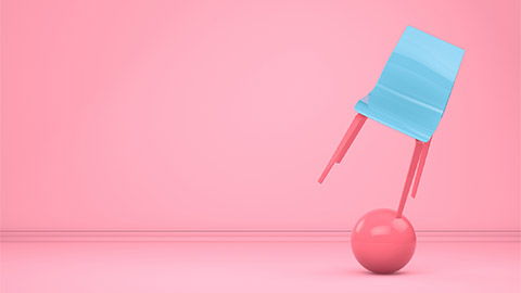 pink background with blue chair balancing on one leg on pik ball