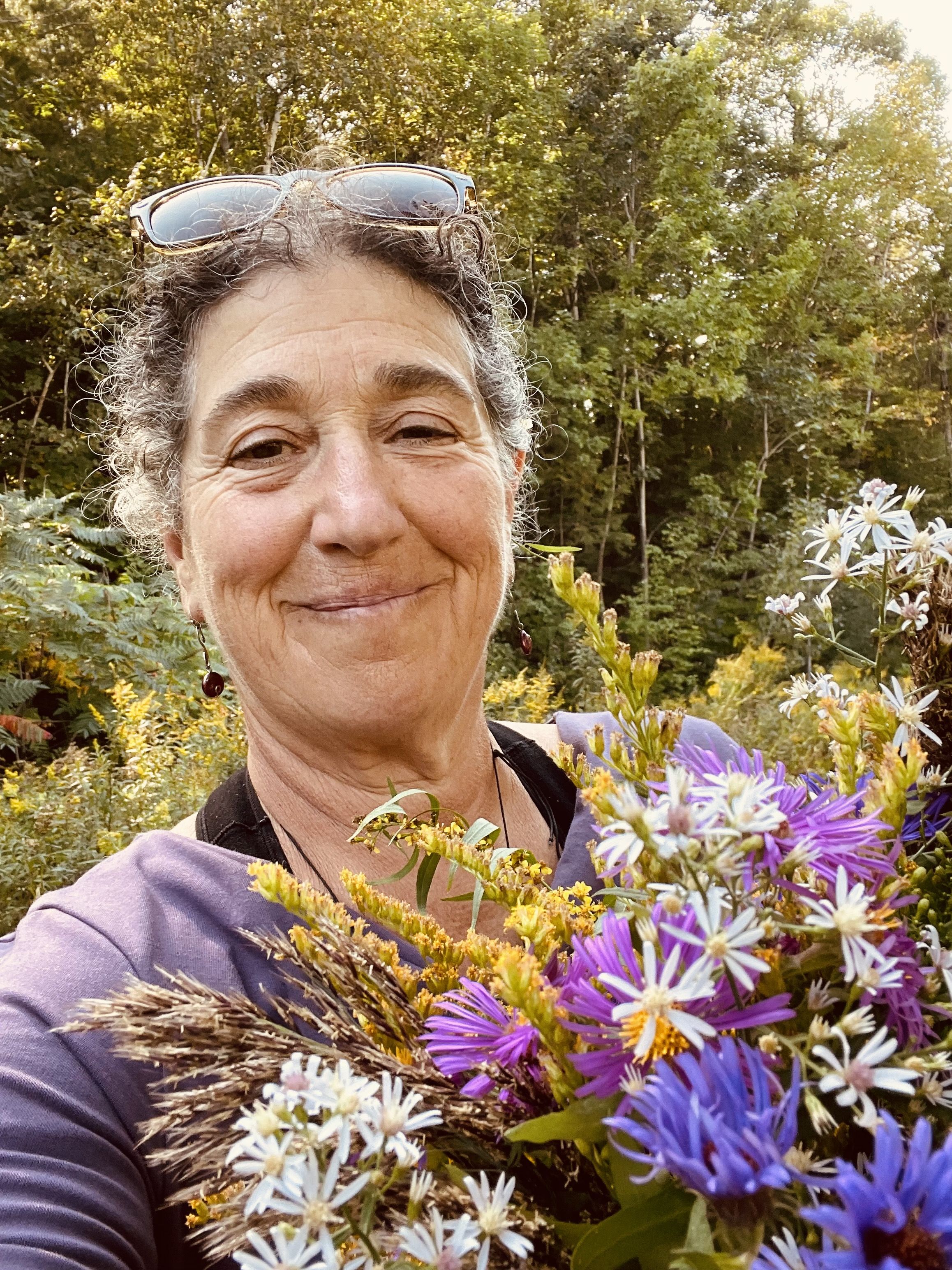 Women smiling holding bunch of wildflowers