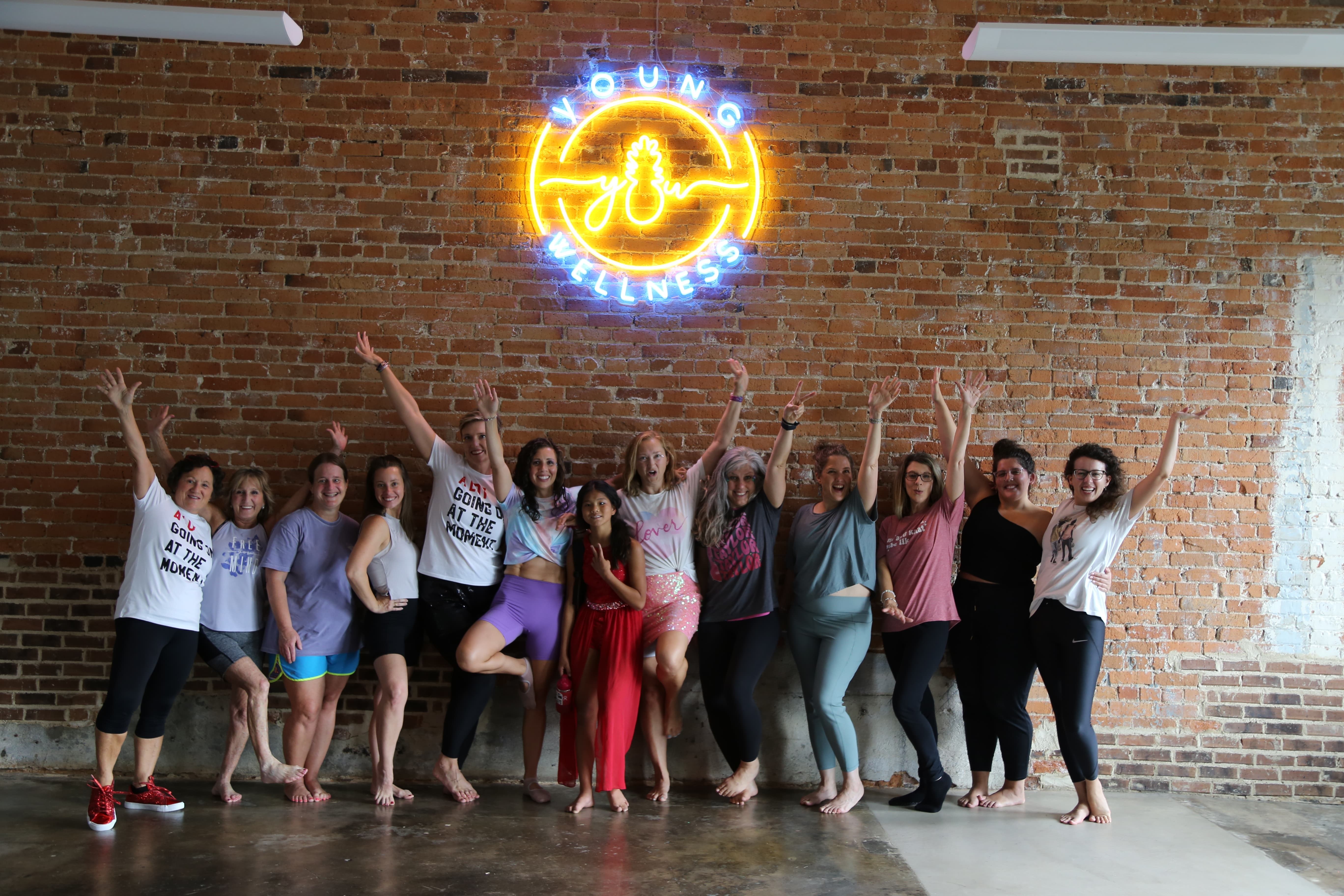 yoga-for-beginners-greenwood-sc group photo of yoga students smiling with arms raised after a yoga class