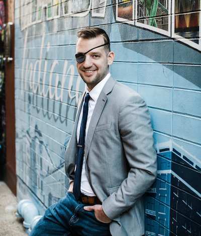 erik propped by wall with mural