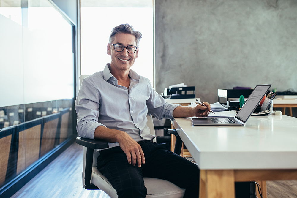 smiling man with laptop