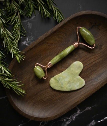 2 jade facial massage tools on wooden tray