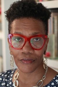author Angela Jackson-Brown in polka dot shirt with red glasses