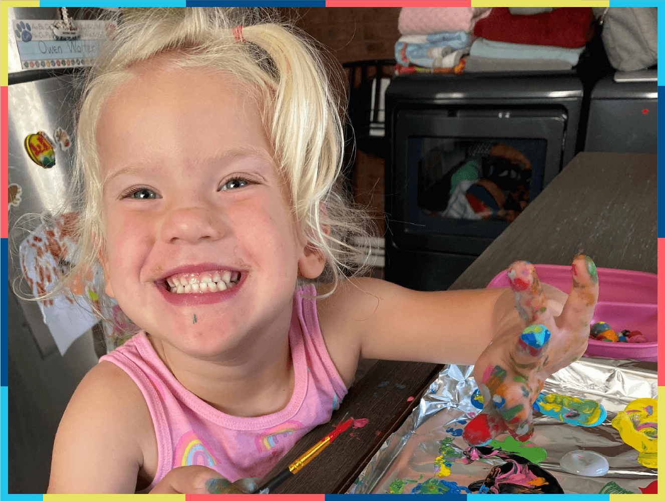 Happy child playing with fingerpaints