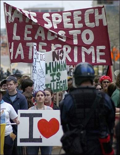 a crowd of students facing police in riot gear