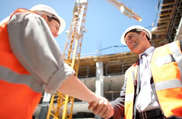 Image of two men shaking hands on a construction site