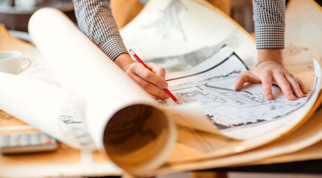 Projecting with pencil on the big urban drawings. Town planning