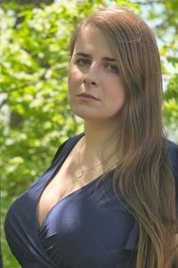 Áine Cain in blue shirt in front of a tree