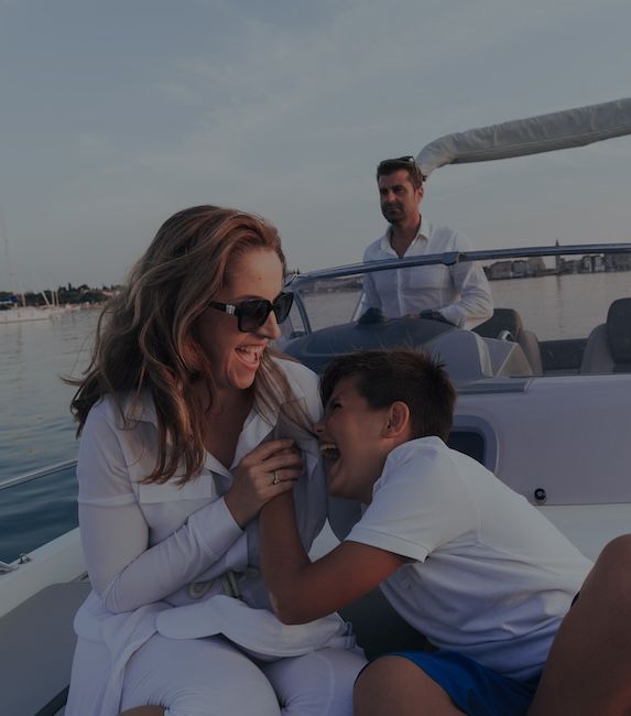 hispanic A senior couple in casual outfits with their son enjoy while riding a boat at sea at sunset.