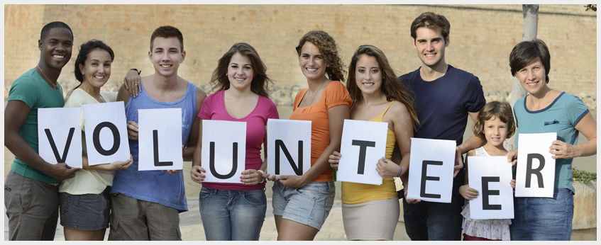 volunteer line of people holding volunteer signs