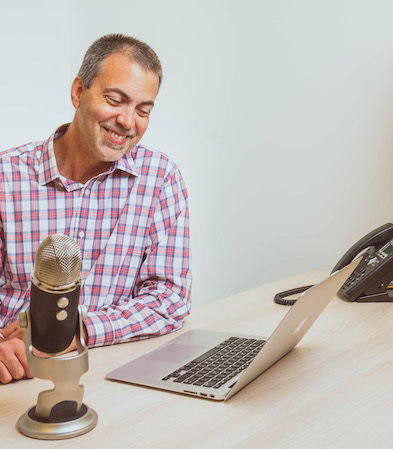 Michael Reynolds sitting by a microphone and computer