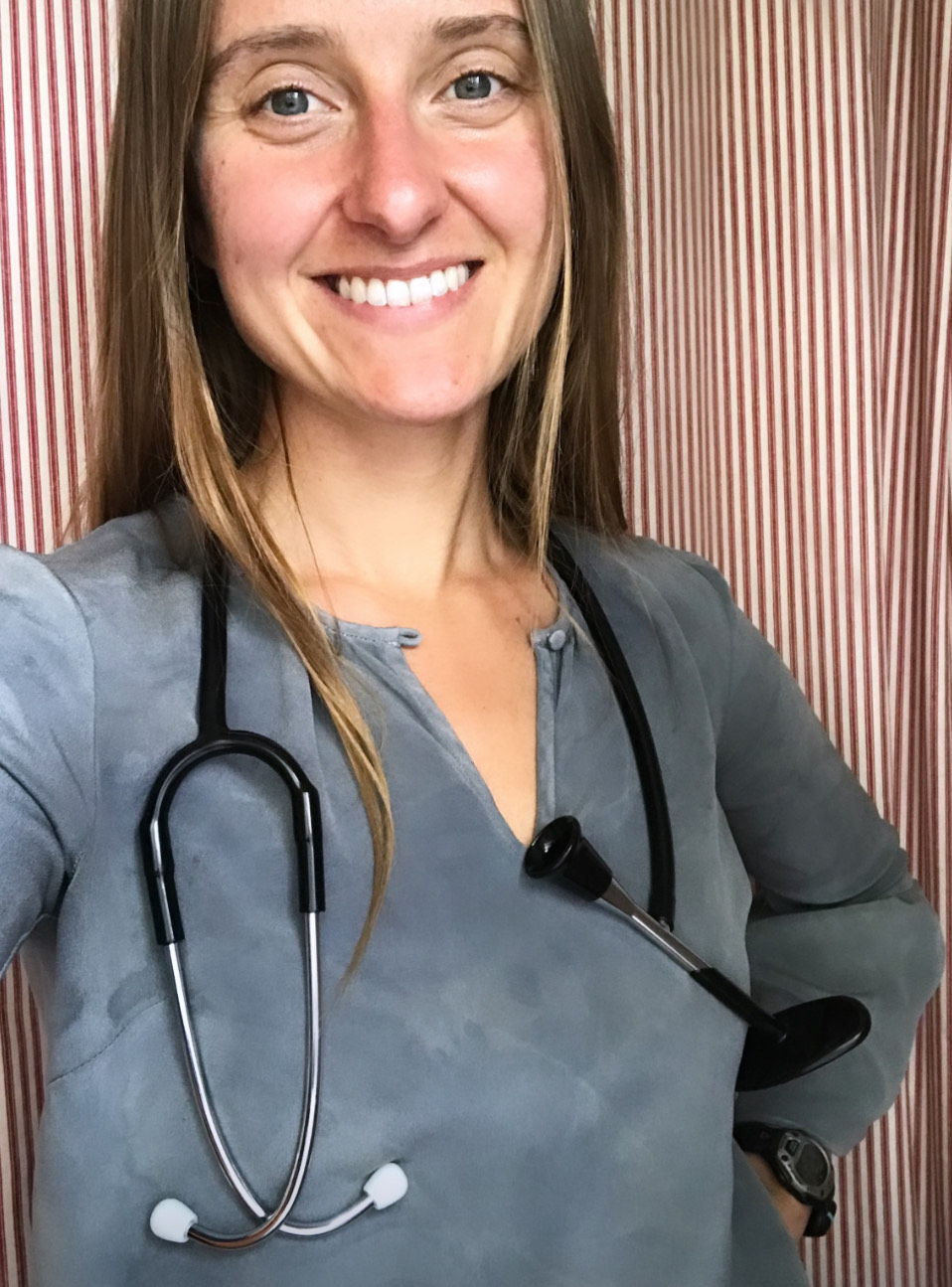 Woman, smiling in gray shirt, with stethoscope around neck