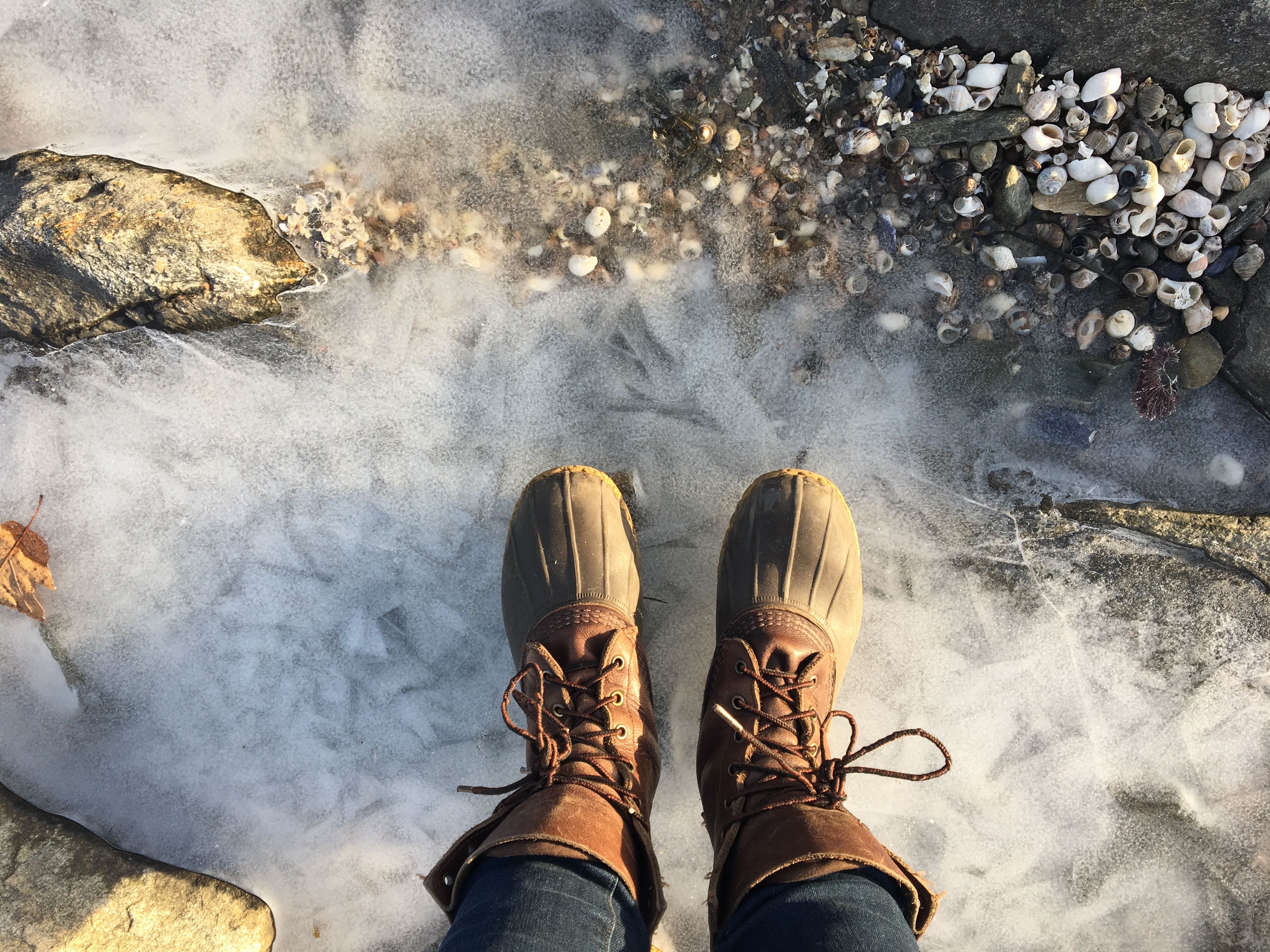 LL Bean winter boots standing on icy ocean water