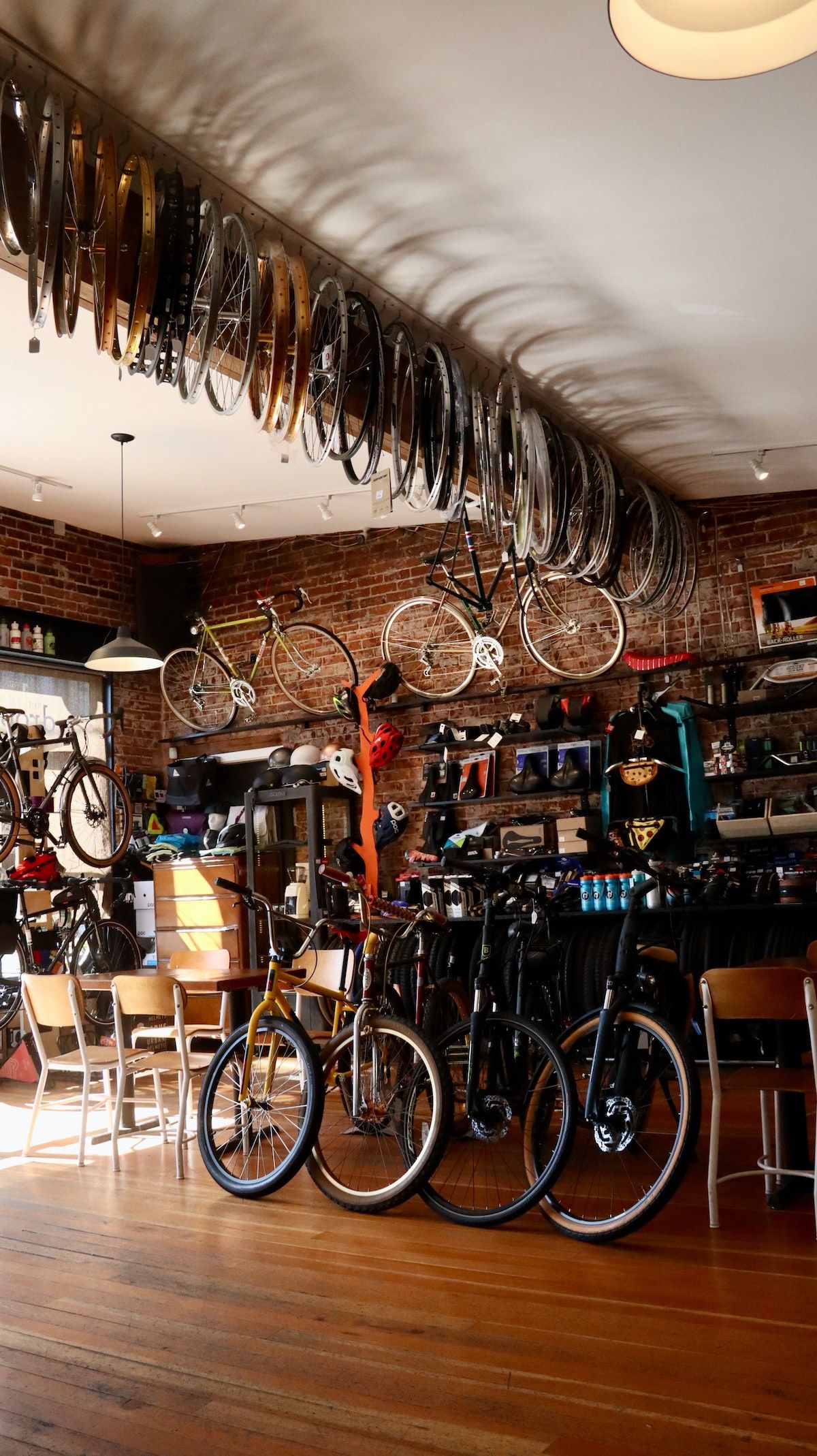 Courtesy of manny-becerra from unsplash Bike store with wooden floors, rims hanging on the ceiling and lots of bikes