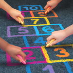 Children hands writing numbers with sidewalk chalk Children hands writing numbers with sidewalk chalk