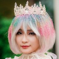 asian woman wearing a sparkly rainbow wig and a crystal crown