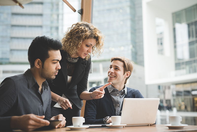 woman meeting two men to discuss project at coffee shop