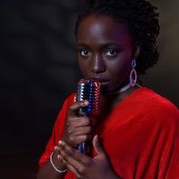 Black woman in a red dress holding a silver microphone