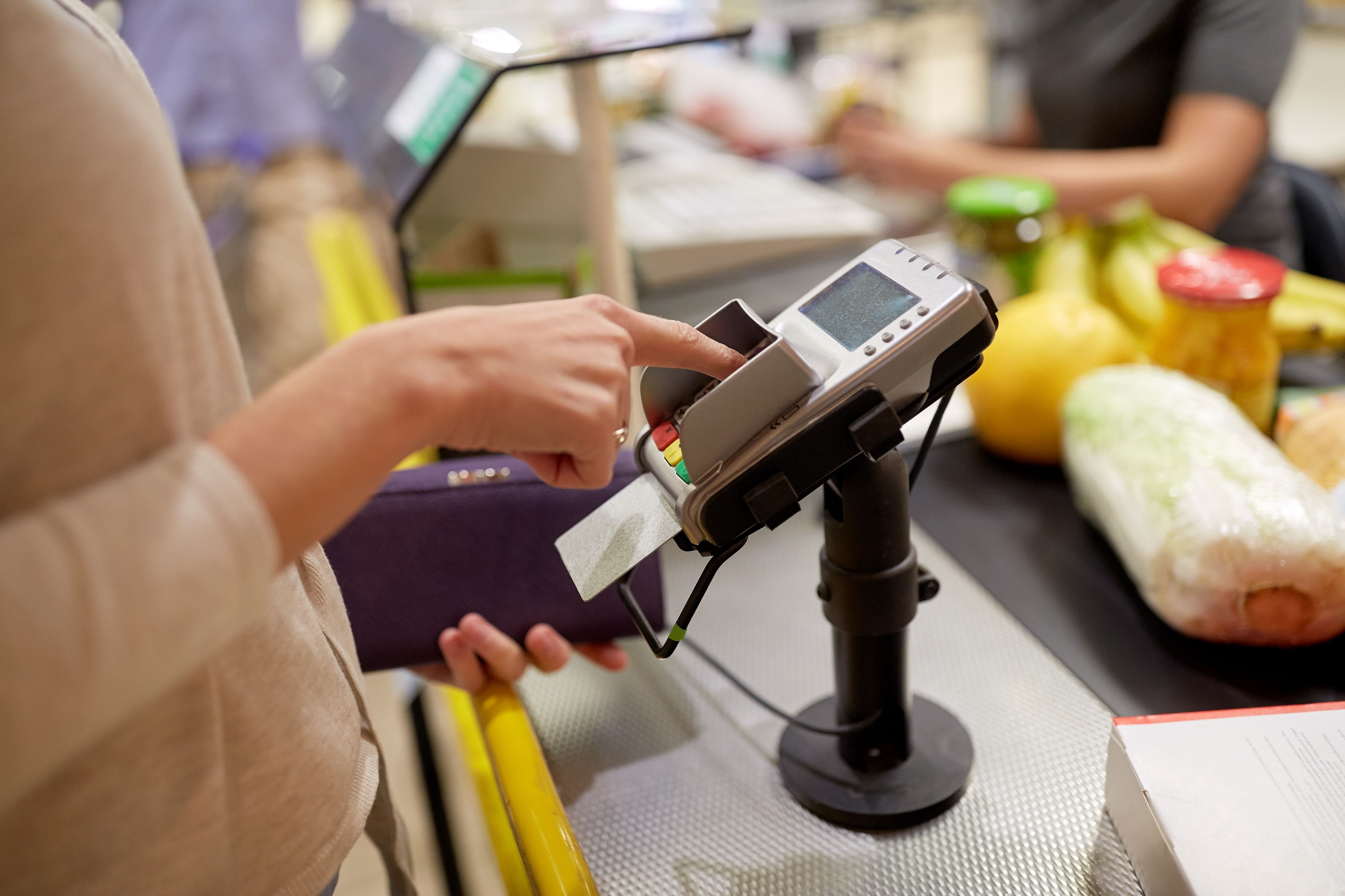 Woman paying for groceries using a credit card