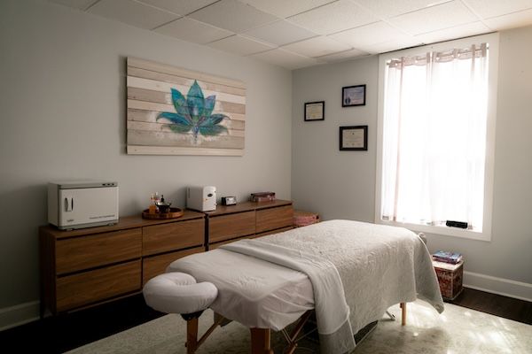 bright massage room with massage table and art