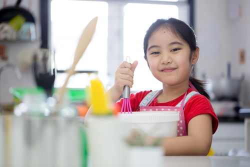 little girl helping make dinner