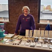 Tracy McQueen in purple shirt in front of informational table