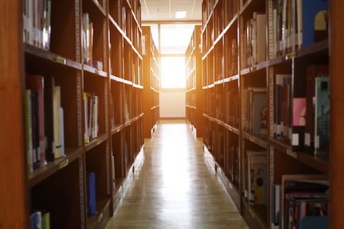 Library bookshelves illuminated with warm light