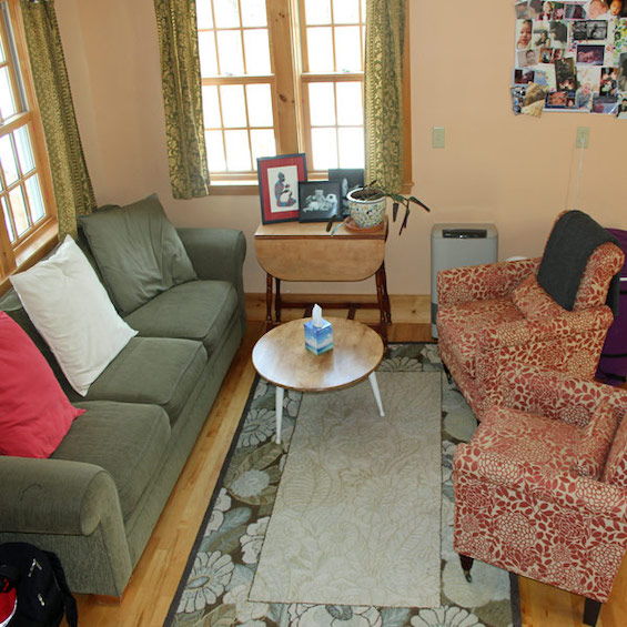 cozy room with green couch and red chairs