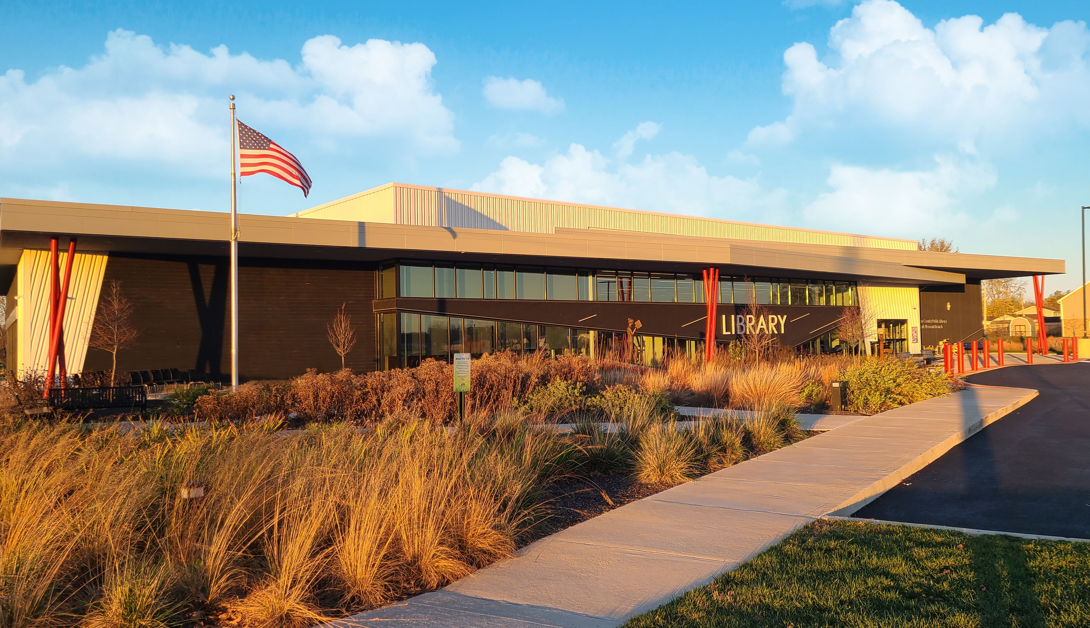 external view of front windows and entrance of the Clark Pleasant Branch, with greenery and the American flag