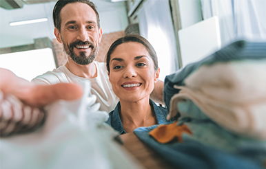 Your clutter is costing you So happy. Delighted bearded male person expressing positivity while helping his girlfriend