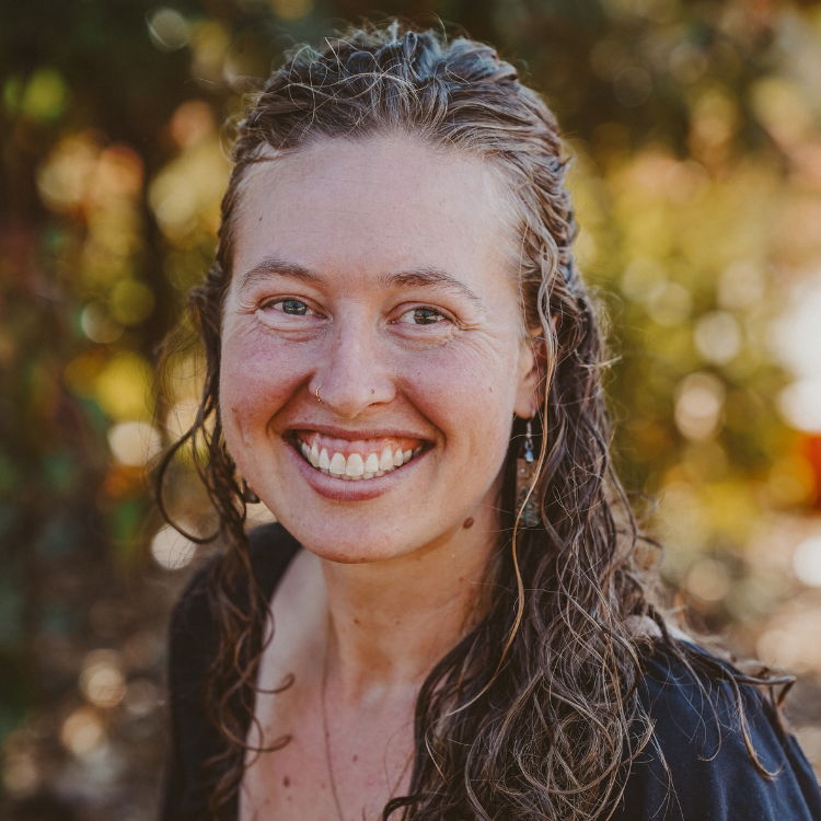 Young woman, smiling with long, curly brown hair