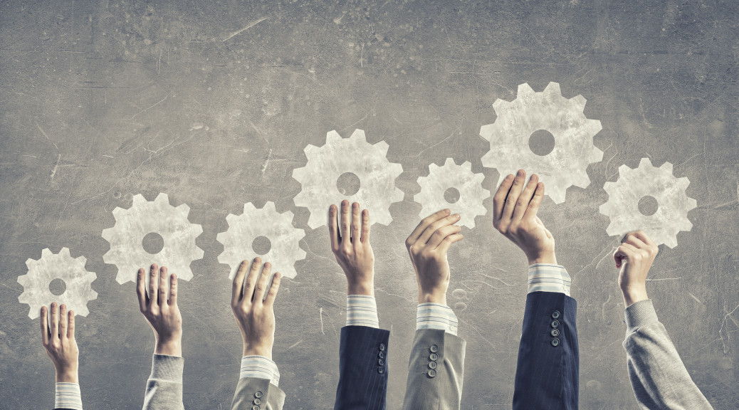 Group of business people with raised hands holding cogwheels