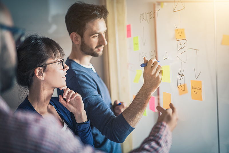 man and woman writing on whiteboard