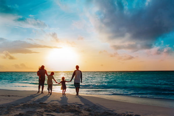 happy family with tree kids walk at sunset beach.jpeg